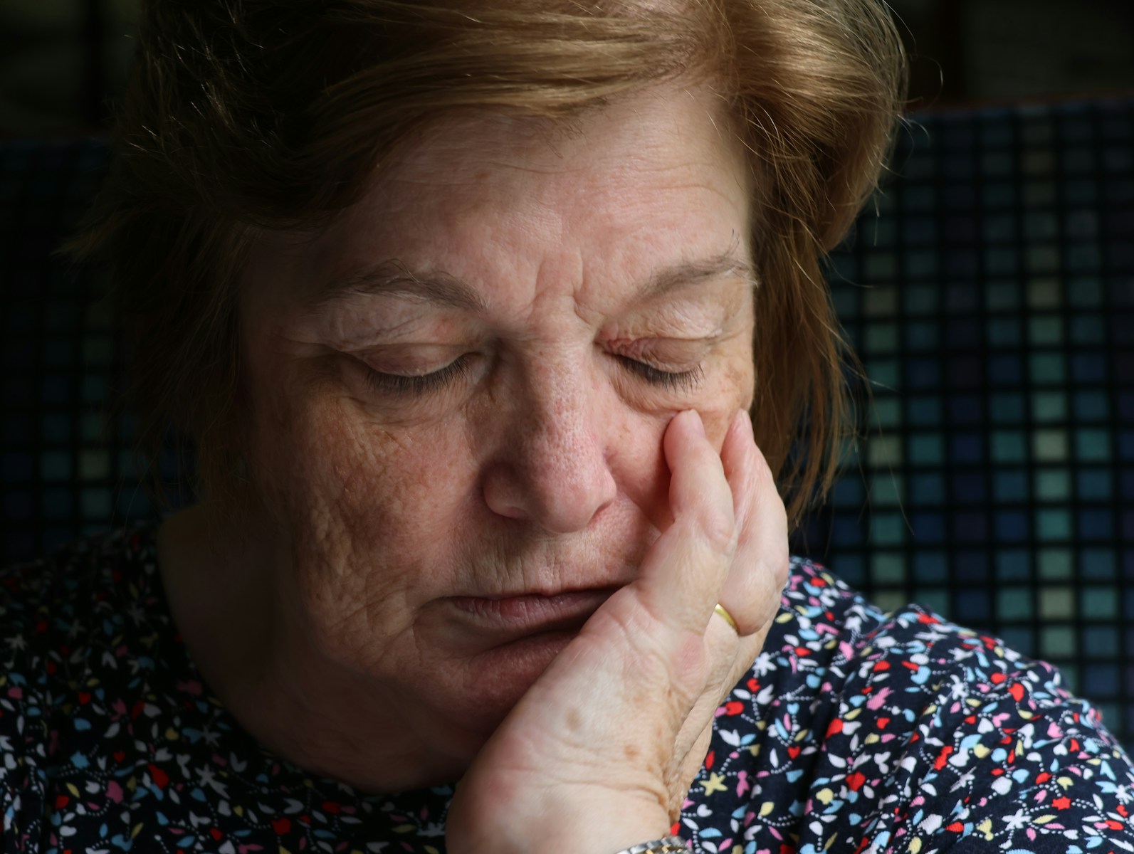 Elderly woman with hand on her cheek